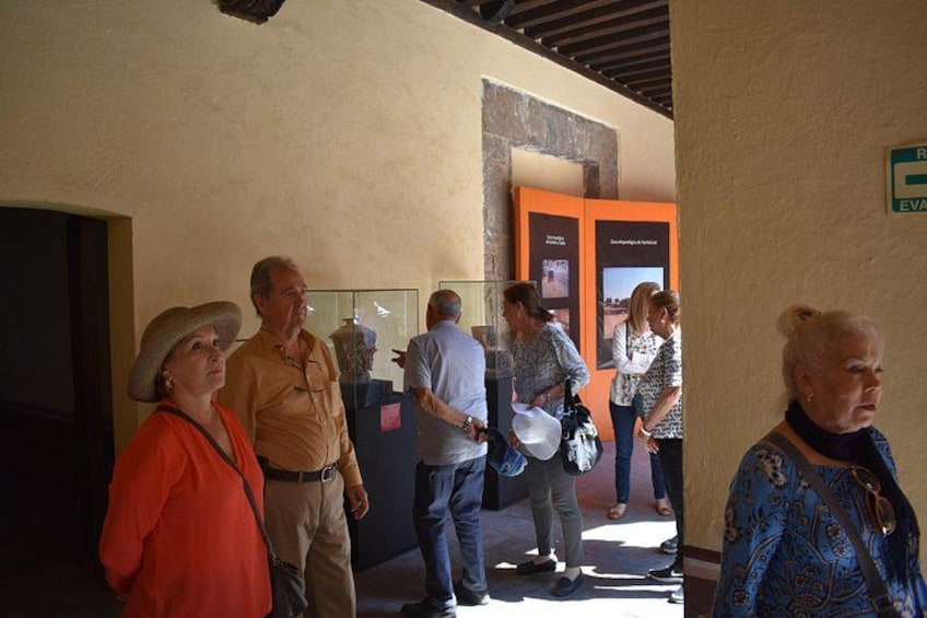 A group of people standing in a hallway with informational posters on the wall. 5