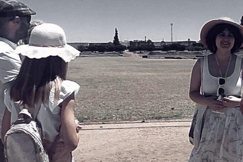 A group of people standing in a field with a clear sky and distant structures. 4