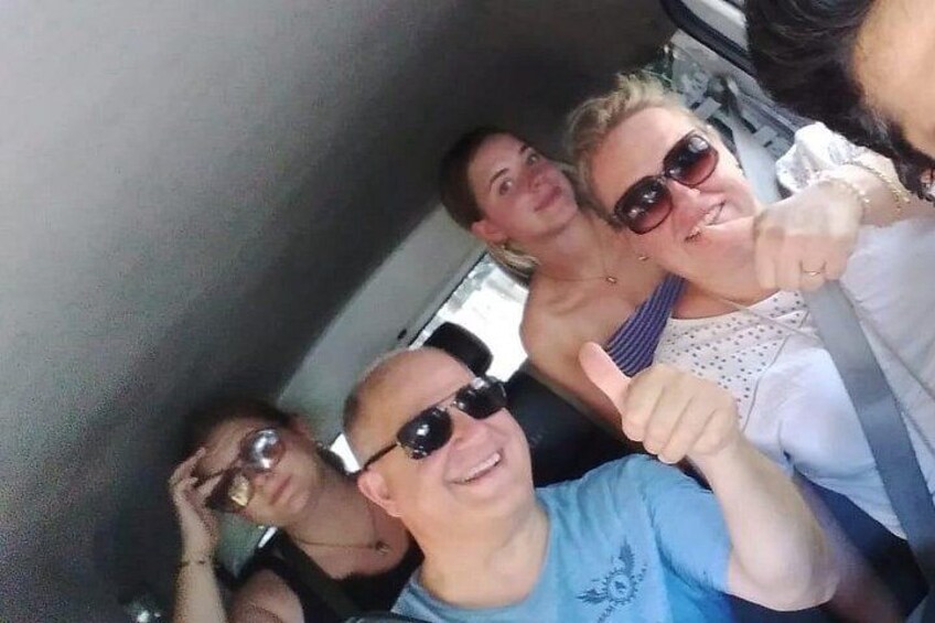 Eine Gruppe von Menschen in einem Fahrzeug, eine Person macht ein Daumen hoch-Zeichen. 4