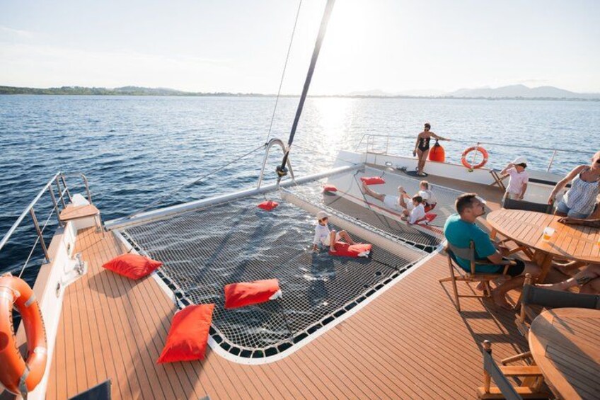 A sailboat with people on deck, a lifebuoy, and a calm sea. 5