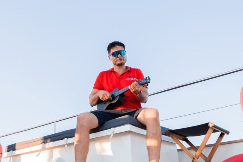 A person sitting on a structure, holding a guitar. 4
