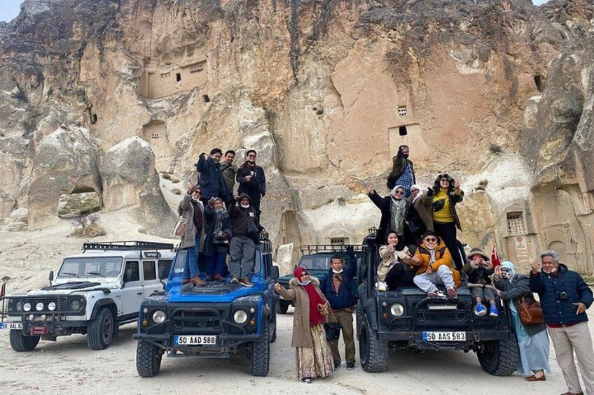Un grupo de personas sobre un afloramiento rocoso con un jeep al frente. 4