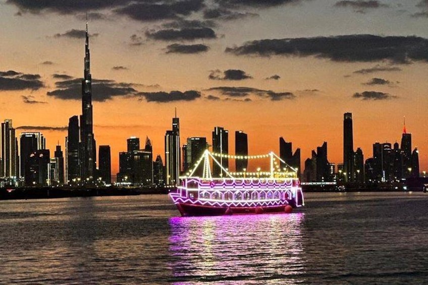A brightly lit boat in the foreground with a city skyline in the background. 1
