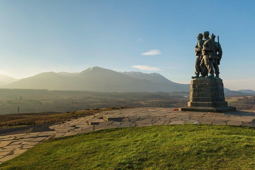 Una estatua sobre un pedestal con un paisaje montañoso al fondo. 3