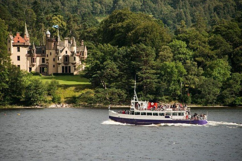Un barco en un río, un castillo en la orilla y un bosque denso al fondo. 5