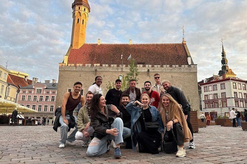 Un grupo de personas posando frente a un edificio histórico con una torre. 1