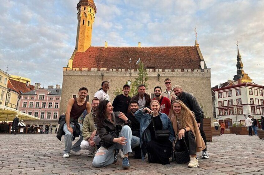 Een groep mensen die poseert voor een historisch gebouw met een toren. 2