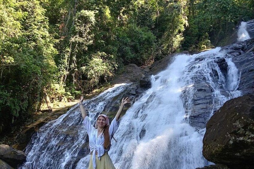 A waterfall with a person standing in front of it. 5