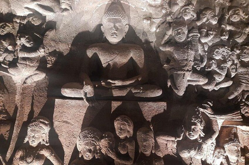 A stone carving with a central figure surrounded by smaller figures. 5