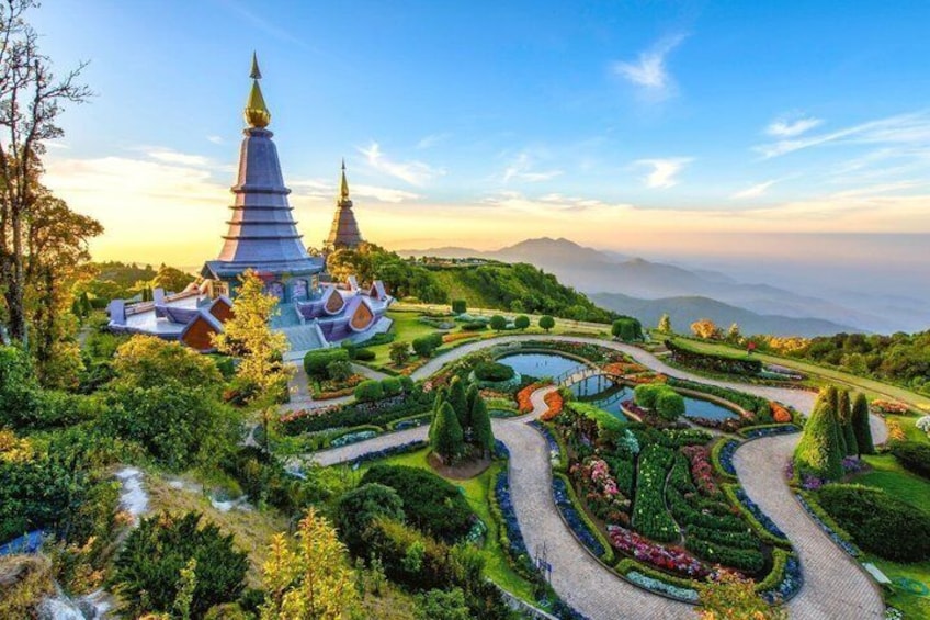 A temple complex with tiered roofs, surrounded by manicured gardens and a winding path. 1