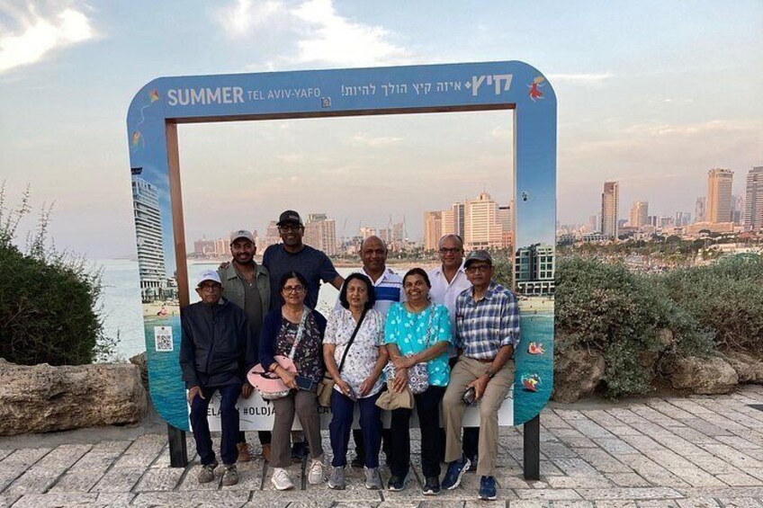 A group of people posing in front of a sign with a cityscape in the background. 4