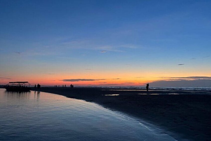 Une plage au coucher du soleil, avec une jetée et des gens qui se promènent. 5