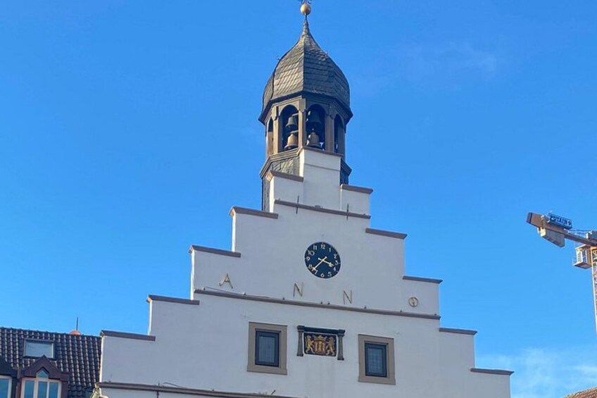 Un edificio bianco con una torre dell'orologio e la scritta 'ANNOS' sulla facciata. 2