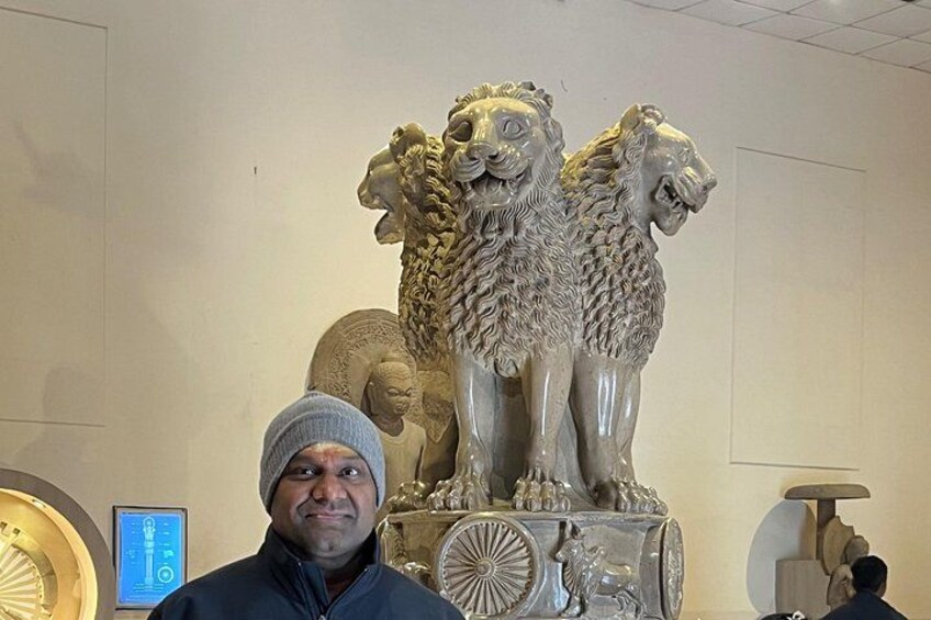 A person standing in front of a sculpture of three lions. 2