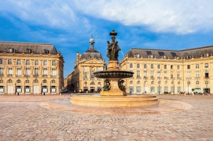 A historic square with a central fountain, surrounded by classical architecture. 2