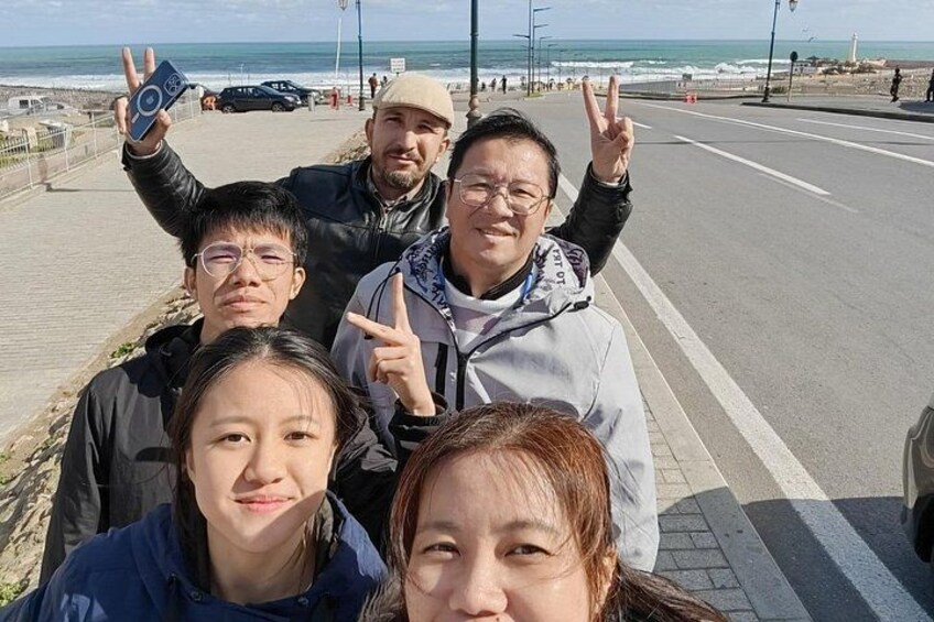 Un grupo de personas caminando por un paseo marítimo con el océano al fondo. 4