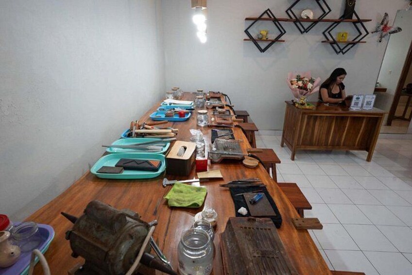 A wooden table with various items including a green tray, a black object, and a green cloth. 3