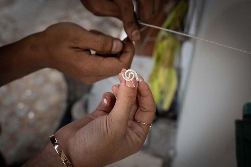 A person performing a manicure, focusing on the intricate design of a nail. 4