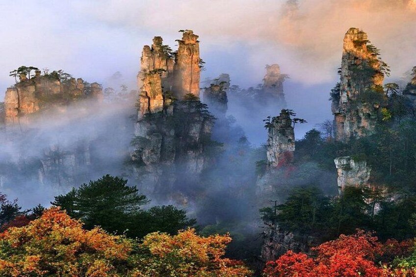 A misty mountain landscape with towering rock formations and dense foliage. 2
