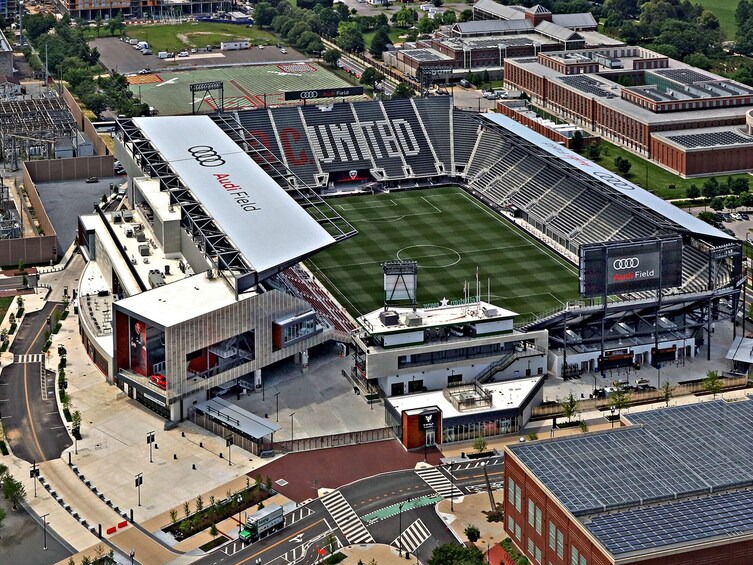 Oversigtsbillede af et stadion med branding for 'Audi Field', omgivet af bygninger og veje. 3