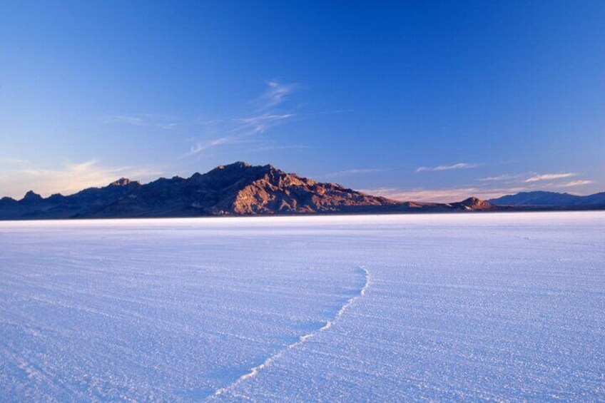 A vast salt flat with a clear sky and distant mountains. 5