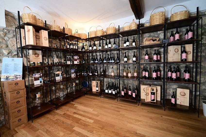 A wine cellar with shelves of wine bottles and baskets. 5