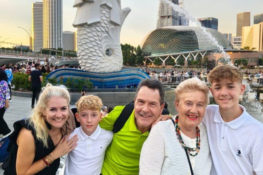 Family group smiling at Merlion Park Singapore during the Omnicity Tours night tour with River Cruise and Marina Bay light shows. 5