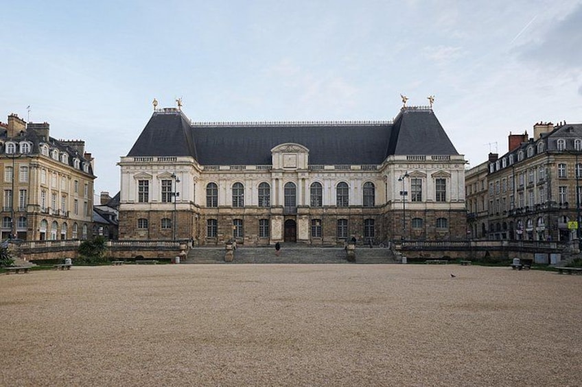 A large historic building with a symmetrical facade, a central entrance, and a courtyard. 2