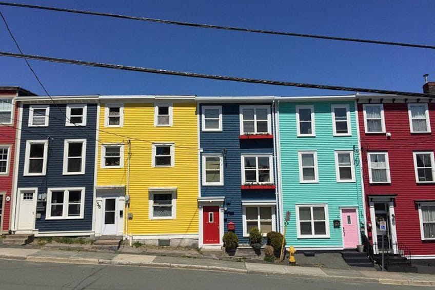 A row of colorful apartment buildings with a yellow fire hydrant in front. 2