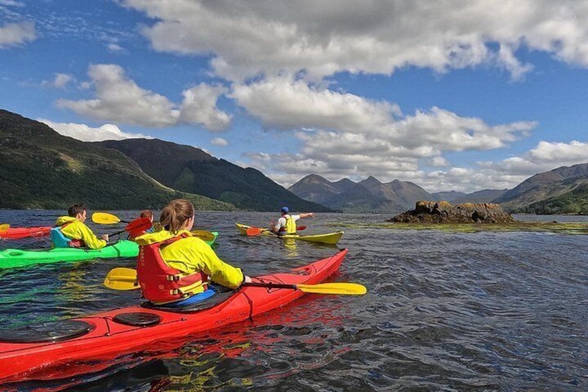 People kayaking on a lake with mountains in the background. 2
