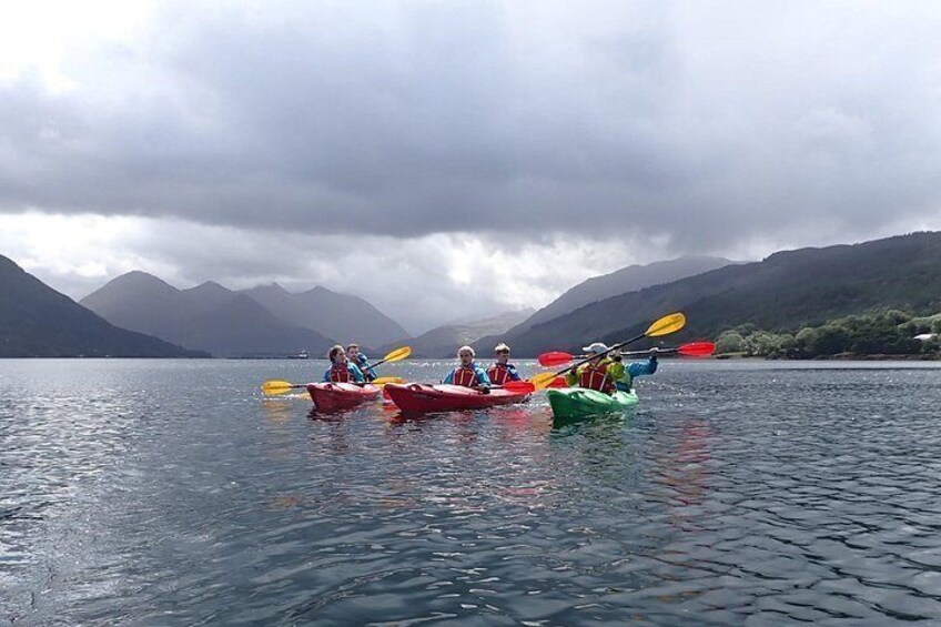 Three kayaks on a calm lake with mountains in the background. 5