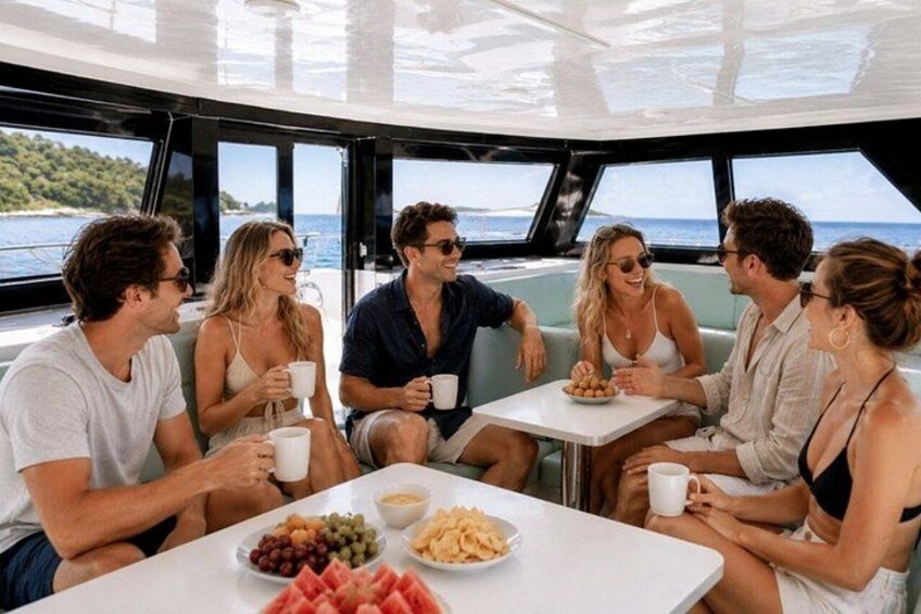 Un grupo de personas en un bote, con una mesa llena de comida y bebidas. 2