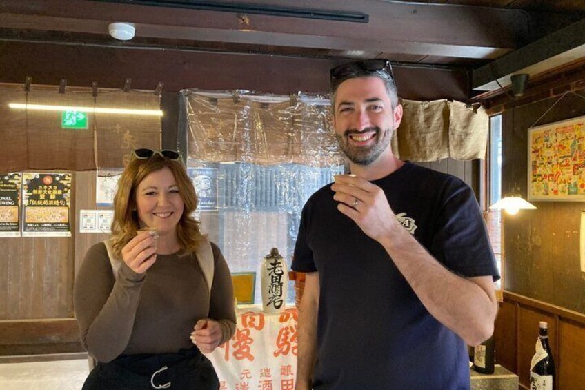 A person standing in a restaurant with wooden interiors and a table with a bottle. 5