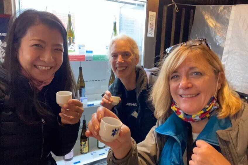 Three people holding cups in a cafe. 1