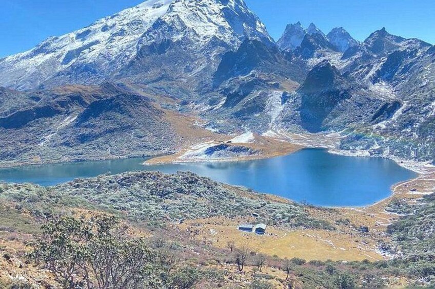 A mountainous landscape with a lake and a small cabin. 4