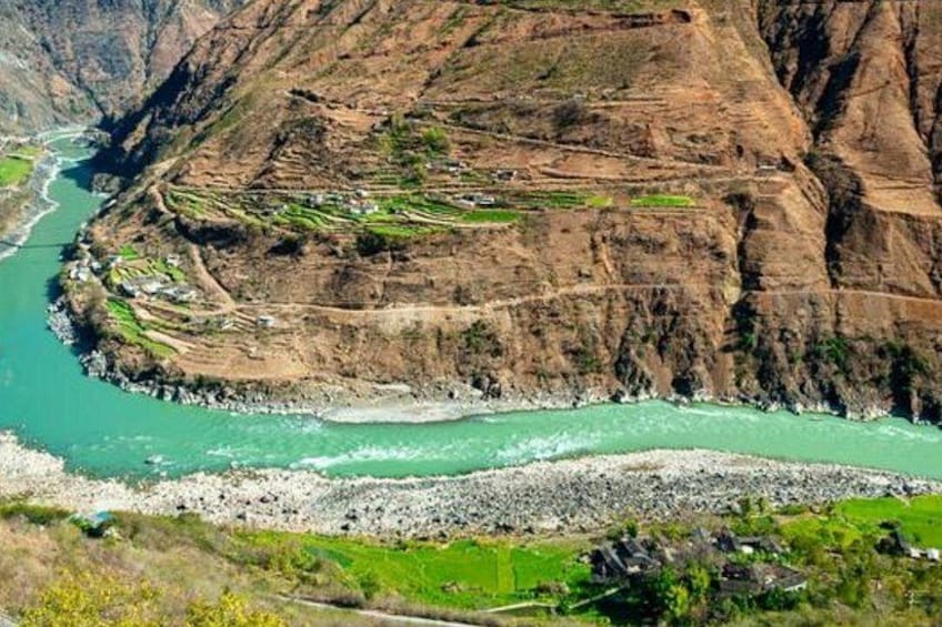 A river winding through a mountainous landscape with terraced fields. 2