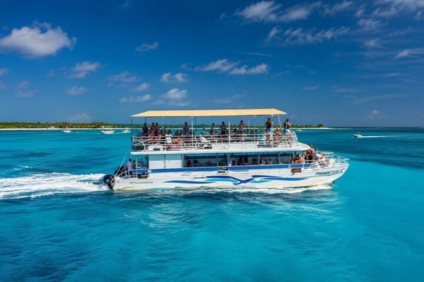 A tour boat with passengers on a clear day over turquoise waters. 1