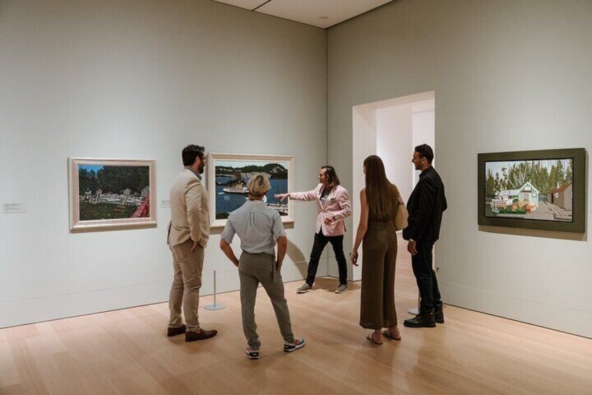 Des personnes visitent une galerie d’art et observent des tableaux. 1