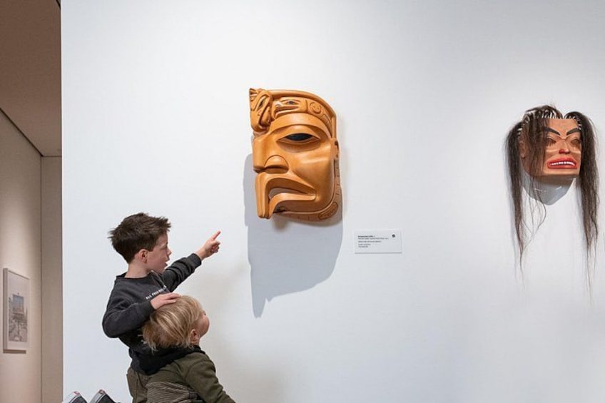 A museum interior with two masks on display. 3