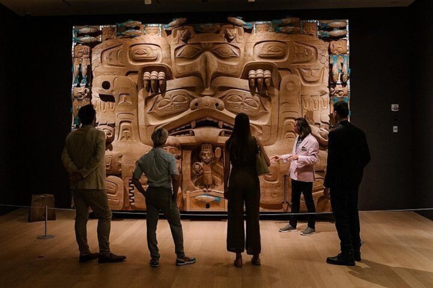 Un groupe de personnes observant une grande sculpture détaillée dans un musée. 2