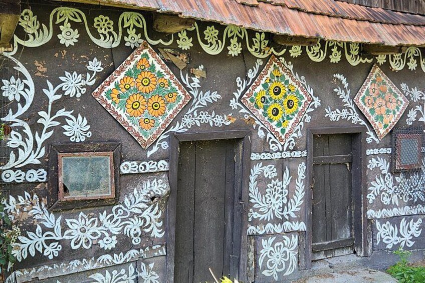 Ein Gebäude mit aufwendigen weißen Blumenmustern und bunten Sonnenblumen an der Fassade. 1