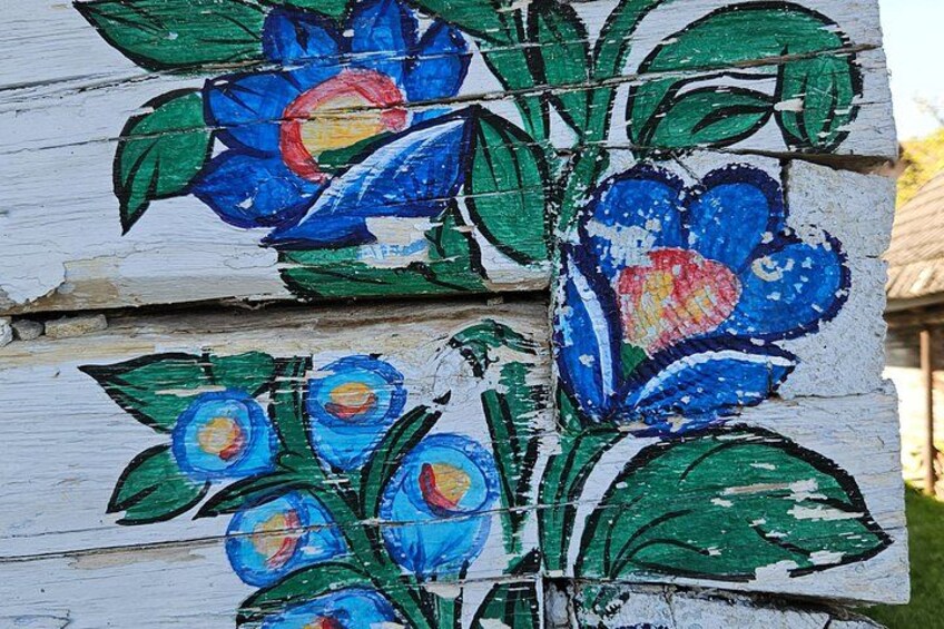 Eine Holzhütte mit bemaltem Blumen- und Blattmuster. 4