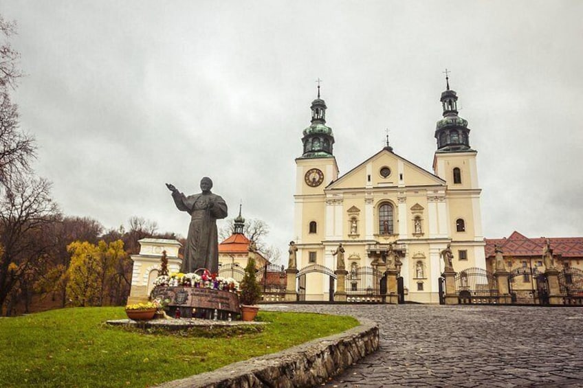 A statue in front of a church with two towers. 3