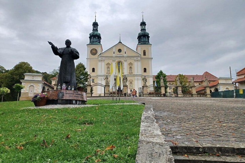 A statue in front of a church with two towers. 5