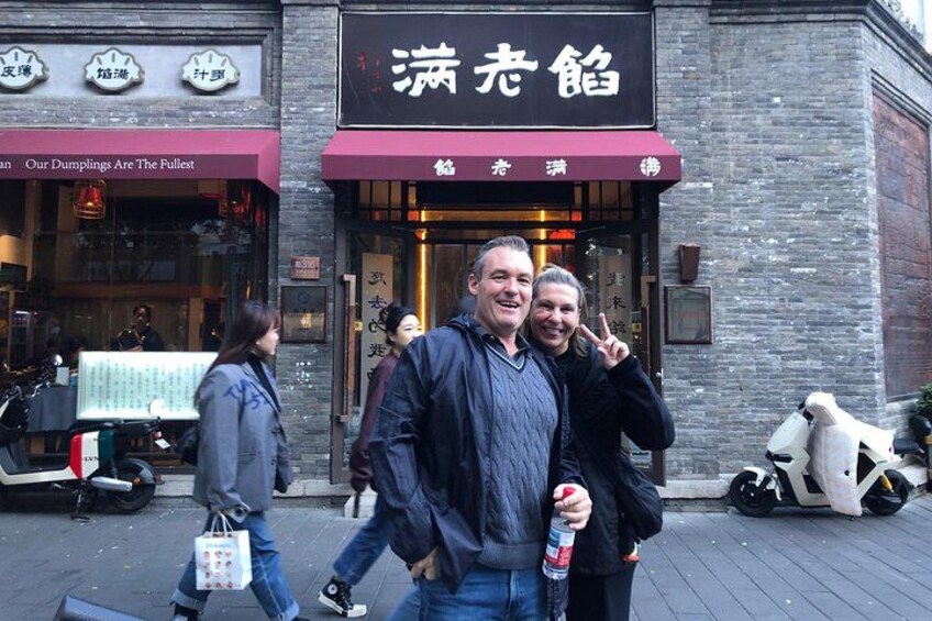 Une rue où se trouve un restaurant appelé « Ming Liang » et où une personne tient une boisson. 3