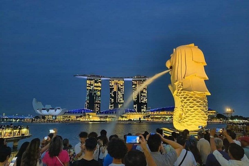A large illuminated sculpture of a dragon's head in front of a modern building complex at night. 4