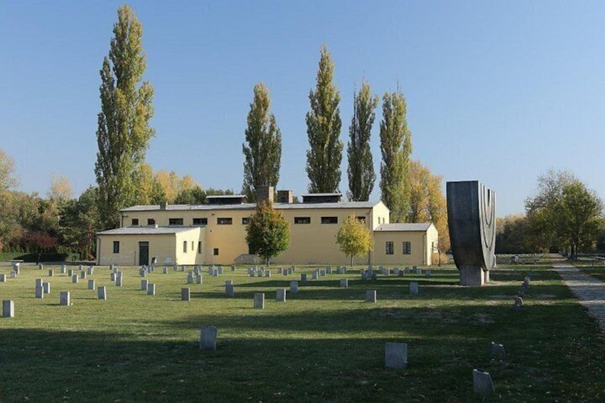 A cemetery with headstones, a building, and a sculpture. 2