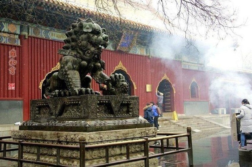 Une statue de lion se trouve devant un bâtiment rouge à l’architecture traditionnelle. 4