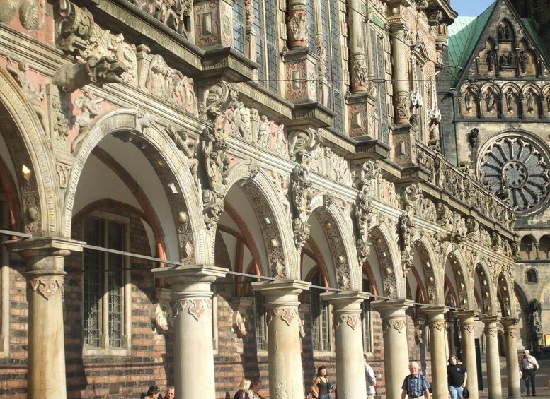 Un edificio histórico con arquitectura ornamentada, que incluye esculturas detalladas y una alta torre con reloj. 2