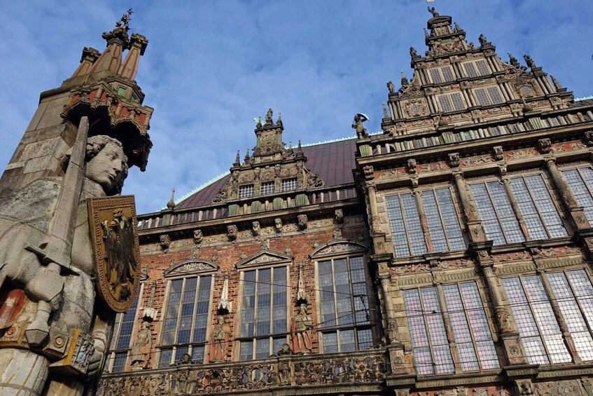 Un edificio histórico con detalles arquitectónicos elaborados, incluyendo estatuas y ventanas ornamentales. 3